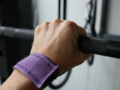 Close up of a hand gripping a barbell handle.